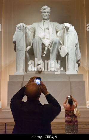 Mann und Frau fotografieren auf Iphones der Abraham Lincoln-Statue in der Memorial-Washington DC Stockfoto