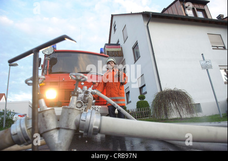 Feuerwehrmann, Feuerwehrauto Wasser aus einem Hydranten zeichnen, während eine Brandbekämpfung Betrieb, Aichelberg, Baden-Württemberg Stockfoto