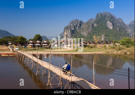 Bambus-Brücke mit dem Moped Fahrer über den Nam Song River, Karstberge, Vang Vieng, Vientiane, Laos, Indochina, Asien Stockfoto