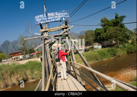 Frau zu Fuß über eine Holzbrücke über den Nam Song River, Vang Vieng, Vientiane, Laos, Indochina, Asien Stockfoto