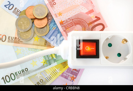 Schaltbare Multi-Stecker Verlängerungskabel, Euro-Banknoten und Münzen, symbolisches Bild für Energiekosten, Stromkosten Stockfoto