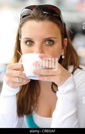 Junge Frau trinken Kaffee, halten Kaffeetasse, Café, Paris, Frankreich, Europa Stockfoto
