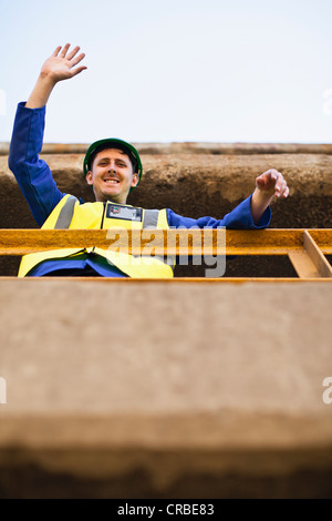 Arbeiter winken vom Balkon Stockfoto