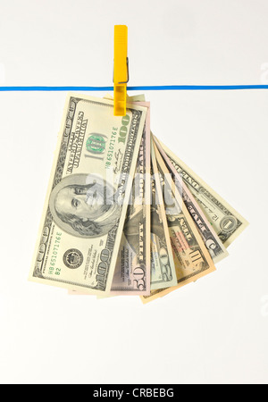 US-Dollar-Banknoten, die an einer Wäscheleine, symbolisches Bild für Geldwäsche, illegales Geld hängen Stockfoto