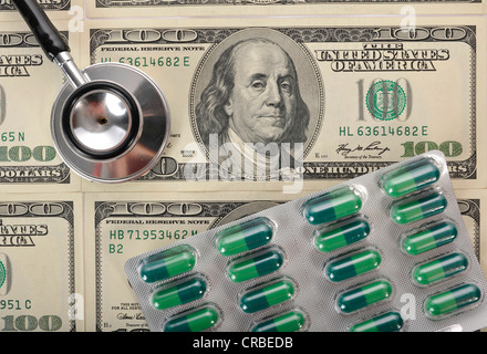 Stethoskop und Kapseln auf US-Dollar-Banknoten, symbolisches Bild einer Kranken US-Währung oder die steigenden Kosten des Gesundheitswesens Stockfoto