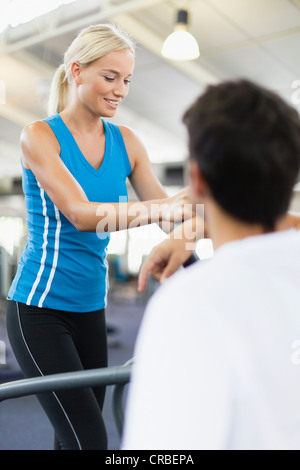 Frau mit Heimtrainer im Fitness-Studio Stockfoto
