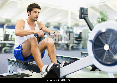 Mann mit Rudergerät im Fitness-Studio Stockfoto