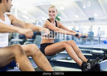 Paar mit Rudergeräte im Fitness-Studio Stockfoto