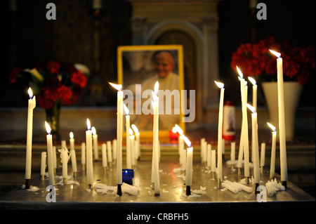 Votivkerzen vor ein Foto von Papst Johannes Paul II. mit Mutter Teresa, Pfarrkirche Église De La Madeleine Stockfoto