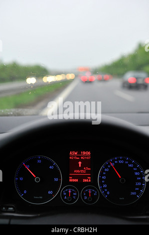 Schlechte Sicht bei Regen, Autobahn, beleuchtete Tachometer mit Navigations-Display, fahren VW Golf Stockfoto