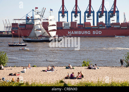 Container-terminal, Segelboot und Sonnenanbeter, Fluss Elbe Ufer in Övelgönne, Hanse Stadt Hamburg, Deutschland, Europa Stockfoto