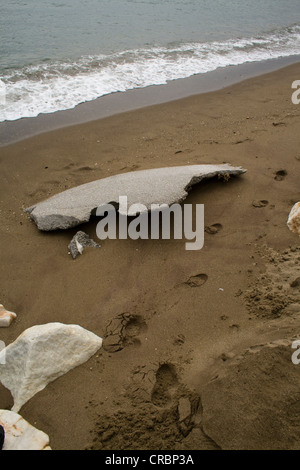 Fußspuren neben schroffen Felsen am Strand Stockfoto