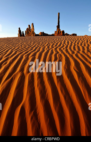 Sanddünen vor Totempfahl und Yei Bi Chei Felsformationen nach Sonnenaufgang, Monument Valley Navajo Tribal Park Stockfoto