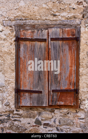 Ein Holzfenster Auslöser festgelegt in einer alten Mauer in das Dorf von Prats-de-Mollo-la-Preste, Languedoc-Roussillon, Frankreich Stockfoto