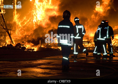 Feuerwehrleute tragen Schutzanzüge, Außerbetriebnahme früh ein Feuer am Festival, Fallas Festival, Annas Festival in Valencia Stockfoto