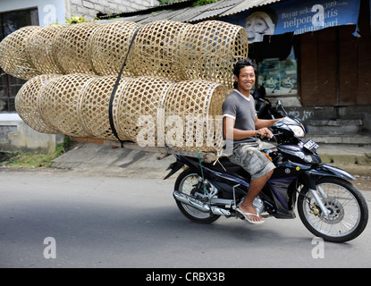 Mann Transport Strohkörbe auf einem Motorrad in Tenganan, Bali, Indonesien, Südostasien Stockfoto