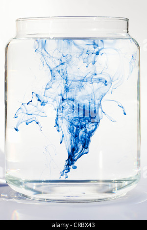 Blaue Flüssigkeit auflösen in Wasser Stockfoto
