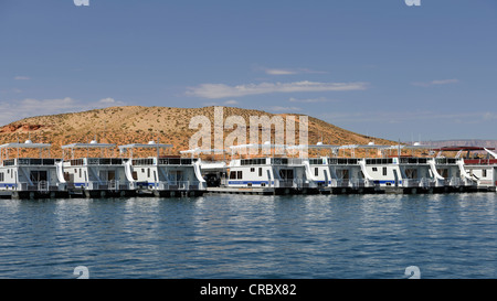 Hausboote zum mieten sind vor Anker im Hafen von Antelope Point Marina mit Turm Butte hinten, Lake Powell, Wahweap Marina, Stockfoto