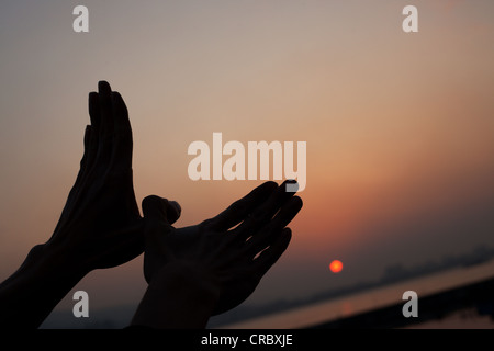 Silhouette von einem Vogel Handzeichen während des Sonnenuntergangs am Fluss Tamsui, Danshui, Taipei, Taiwan Stockfoto