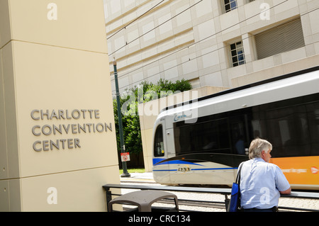 Ein Mann steht vor dem Charlotte Convention Center schaut zu, wie der Lynx Stadtbahn Zug für South Charlotte fährt. Stockfoto