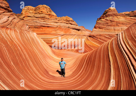 Tourist in The Wave, gebändert erodiert Navajo Sandsteinfelsen mit Liesegang Bands, Liesegangen Ringe oder Liesegang-Ringe, Norden Stockfoto