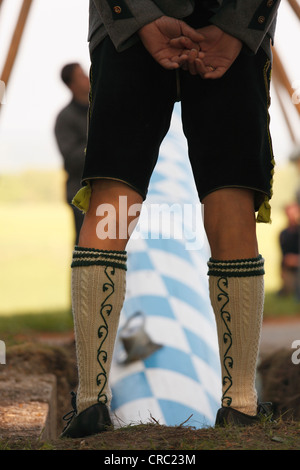 Mann in traditioneller Tracht beobachten, die Anhebung der Maibaum, Holzhausen am Starnberger See, Muensing Gemeinschaft Stockfoto