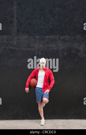 Porträt eines jungen Sportlers hält basketball Stockfoto