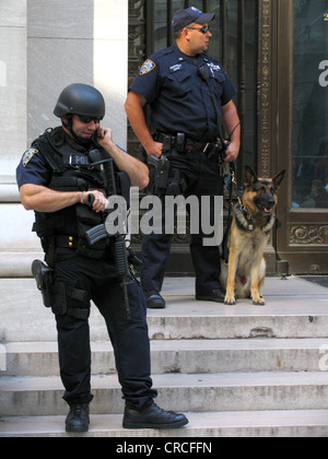 Schwer bewaffnete Polizisten mit Maschinengewehr und Polizeihund an New Yorker Börse Terceira an Wall Street, USA, New York City, Manhattan Stockfoto