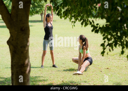 Zwei schöne Frauen dehnen im Stadtpark nach Lauf- und sportliche Aktivität
