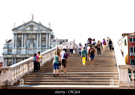 Menschen auf der Treppe an der Ponte Degli Scalzi Brücke über den Canal Grande, St. Lucia Kirche, Cannaregio, Venedig, Italien Stockfoto