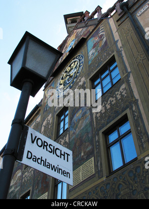 Schild mit der Aufschrift "Achtung Lawinengefahr vom Dach" vor einem Haus mit einem alten und künstlerische Wand mit einer herrlichen Wand Uhr, Deutschland, Baden-Württemberg, Ulm Stockfoto