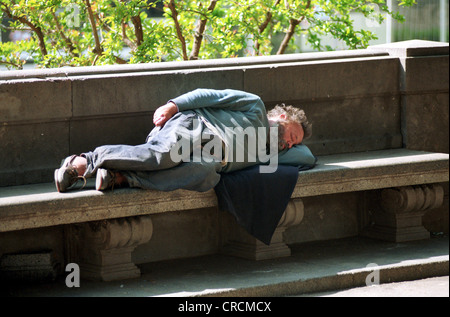 Spanien, ein Obdachloser schläft auf einer Bank in Barcelona Stockfoto