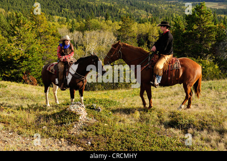 Ein Cowgirl und ein Cowboy sitzt auf ihre Pferde, Saskatchewan, Kanada Stockfoto