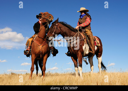 Ein Cowgirl und ein Cowboy sitzt auf ihre Pferde, Saskatchewan, Kanada Stockfoto