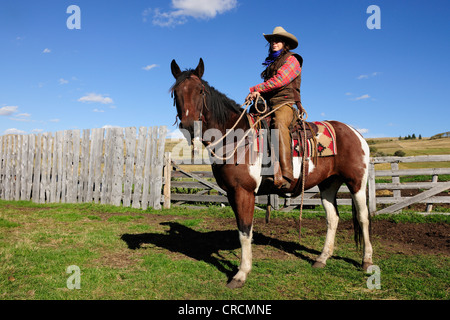 Cowgirl sitzt auf einem Pferd in den Pferch, Saskatchewan, Kanada Stockfoto