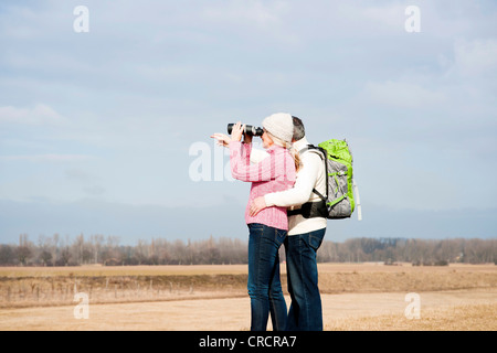 Paar steht auf Wiese mit dem Fernglas Stockfoto