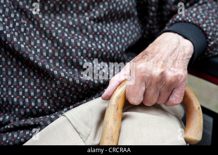 Hand eines älteren Mannes hält einen Spazierstock Stockfoto