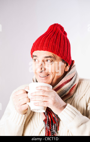 Happy senior woman in Winterkleidung Tasse Tee trinken Stockfoto