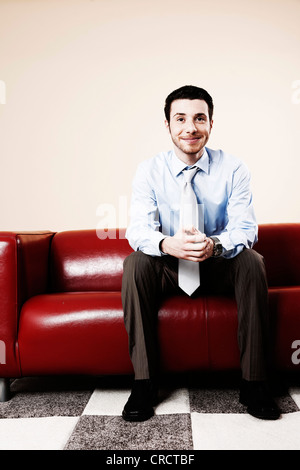 Junger Mann auf sofa Stockfoto