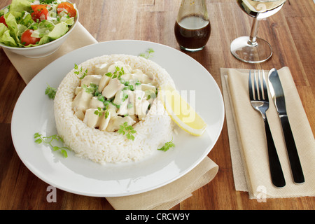 Hühnerfrikassee mit Spargel, Erbsen und Pilze in einem Ring aus Weißwein, Worcestershire-Sauce, Salat, Reis Stockfoto