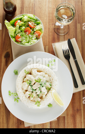 Hühnerfrikassee mit Spargel, Erbsen und Pilze in einem Ring aus Weißwein, Worcestershire-Sauce, Salat, Reis Stockfoto