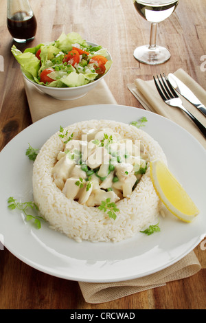 Hühnerfrikassee mit Spargel, Erbsen und Pilze in einem Ring aus Weißwein, Worcestershire-Sauce, Salat, Reis Stockfoto