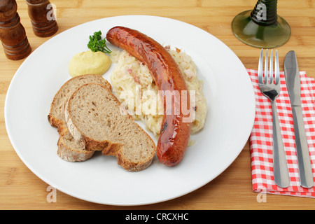 Krakowska geräucherte polnische Chorizo auf Sauerkraut, knusprigem Brot und Senf Stockfoto
