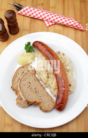 Krakowska geräucherte polnische Chorizo auf Sauerkraut, knusprigem Brot und Senf Stockfoto
