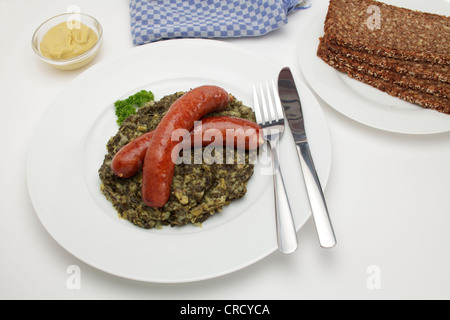 Mettwurst geräuchert Würstchen auf Grünkohl mit Senf und Brot Stockfoto