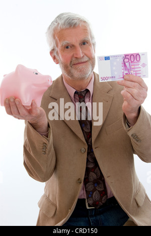 älterer Mann mit Sparschwein und Geld Stockfoto