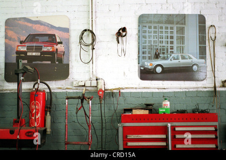 Werkzeuge und Auto Poster an der Wand in einer Autowerkstatt Stockfoto