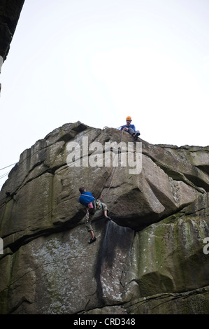 Kletterer auf The Crack auf Cratcliffe Felsen im Peak District, Derbyshire, UK Stockfoto