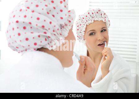 Junge Frau, die sich die Zähne putzen Stockfoto