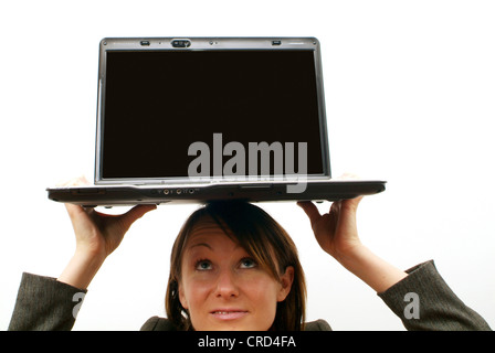 junge Geschäftsfrau mit Laptop auf Kopf Stockfoto